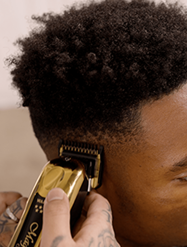 Barber using Wahl Gold Magic Clip Cordless clipper to blend a fade haircut