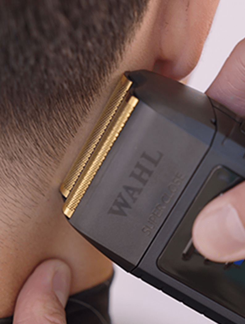 Barber using Wahl Vanish shaver to make clean lines on model's neck